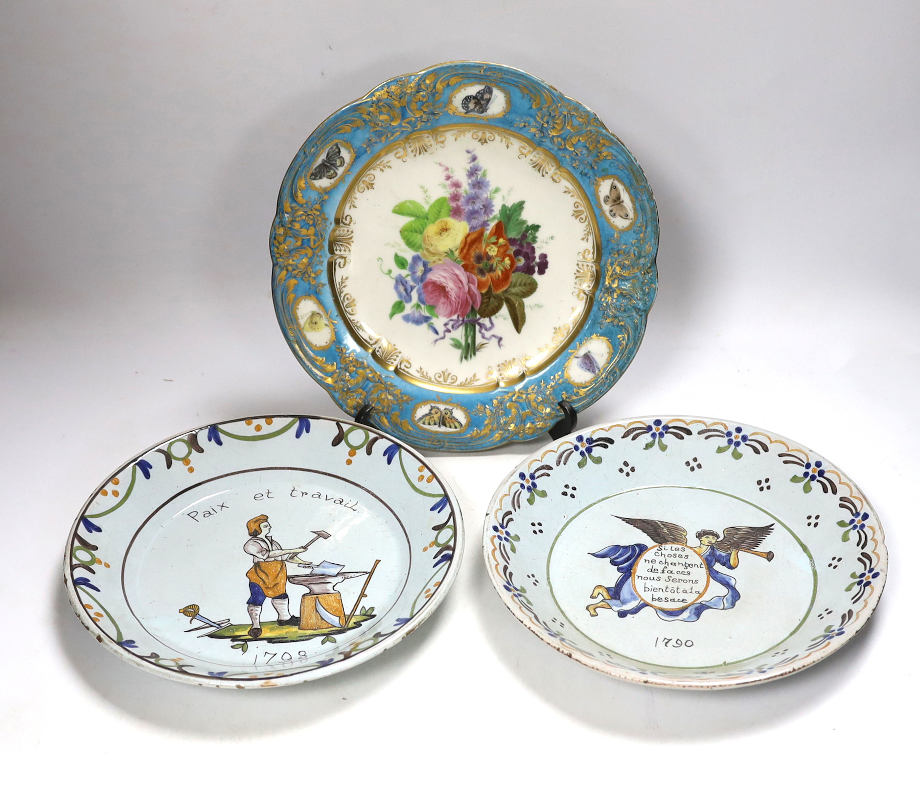 A pair of French revolution commemorative faience dishes and an 18th century Sevres plate, with later decoration, largest 23cm in diameter
